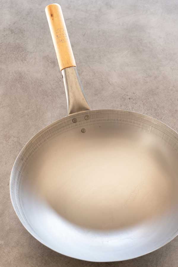 a new unseasoned carbon steel wok on a table