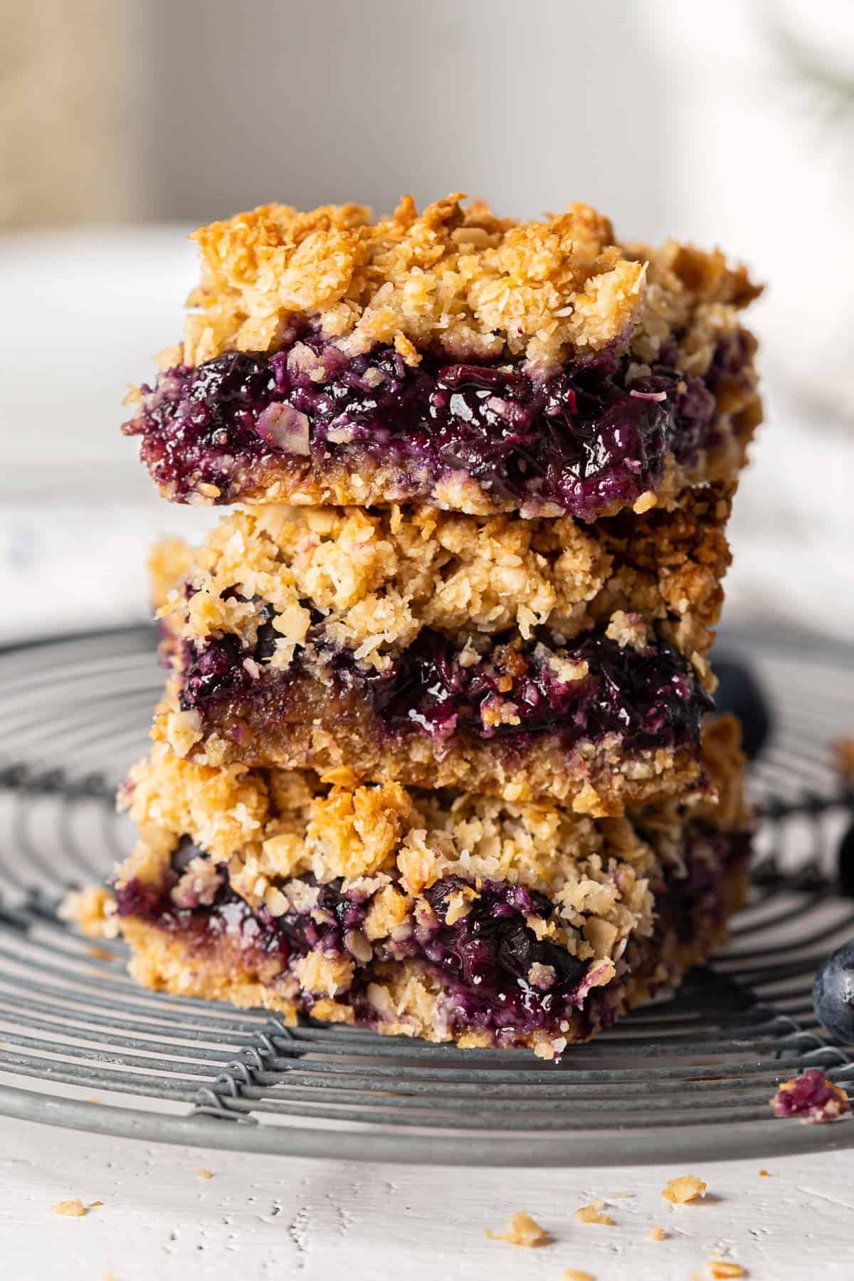 A stack of healthy blueberry crumb bars on a rack.