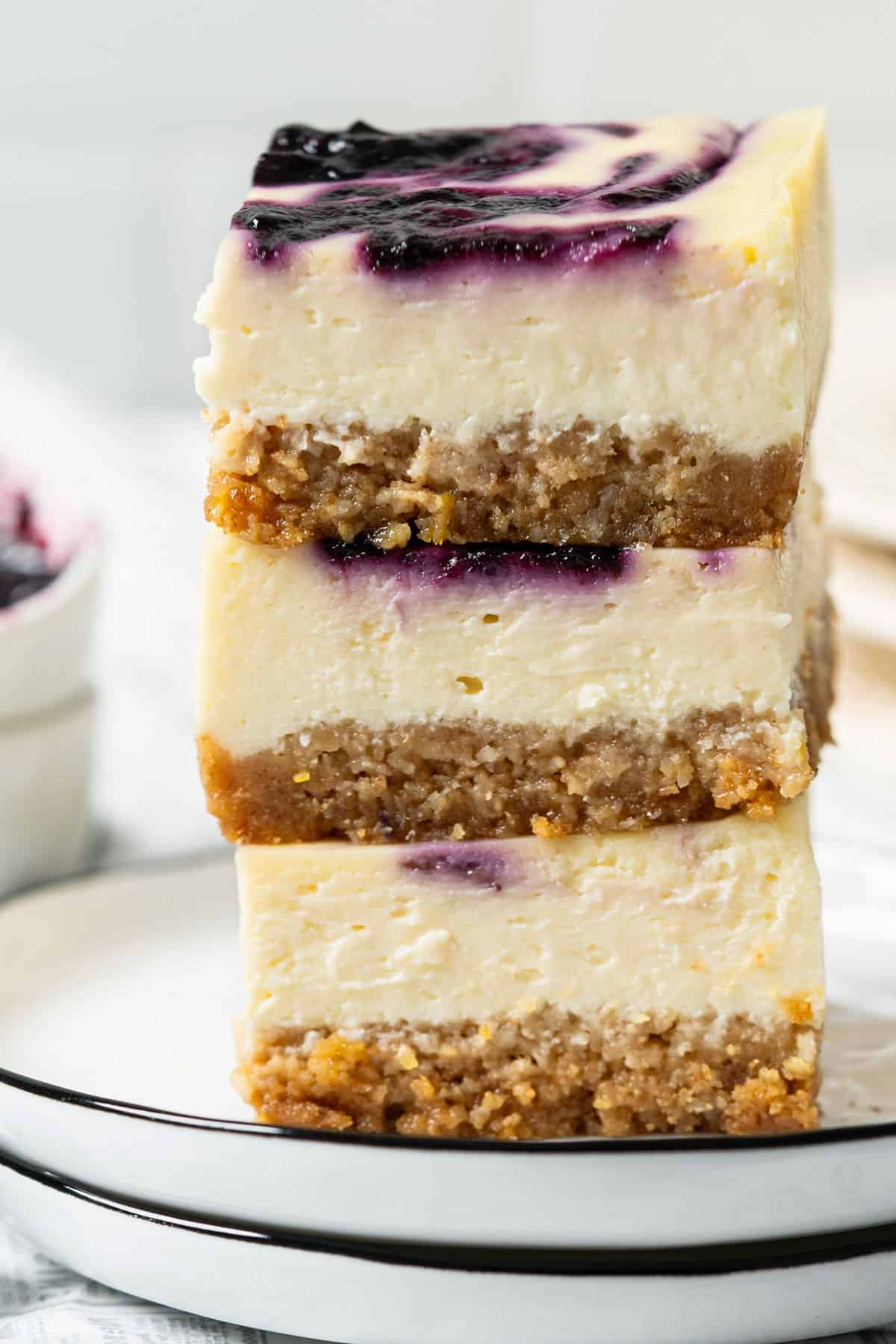 Stacked cheesecake bars on a plate.