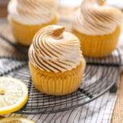 Lemon meringue cupcakes on a cooling rack.