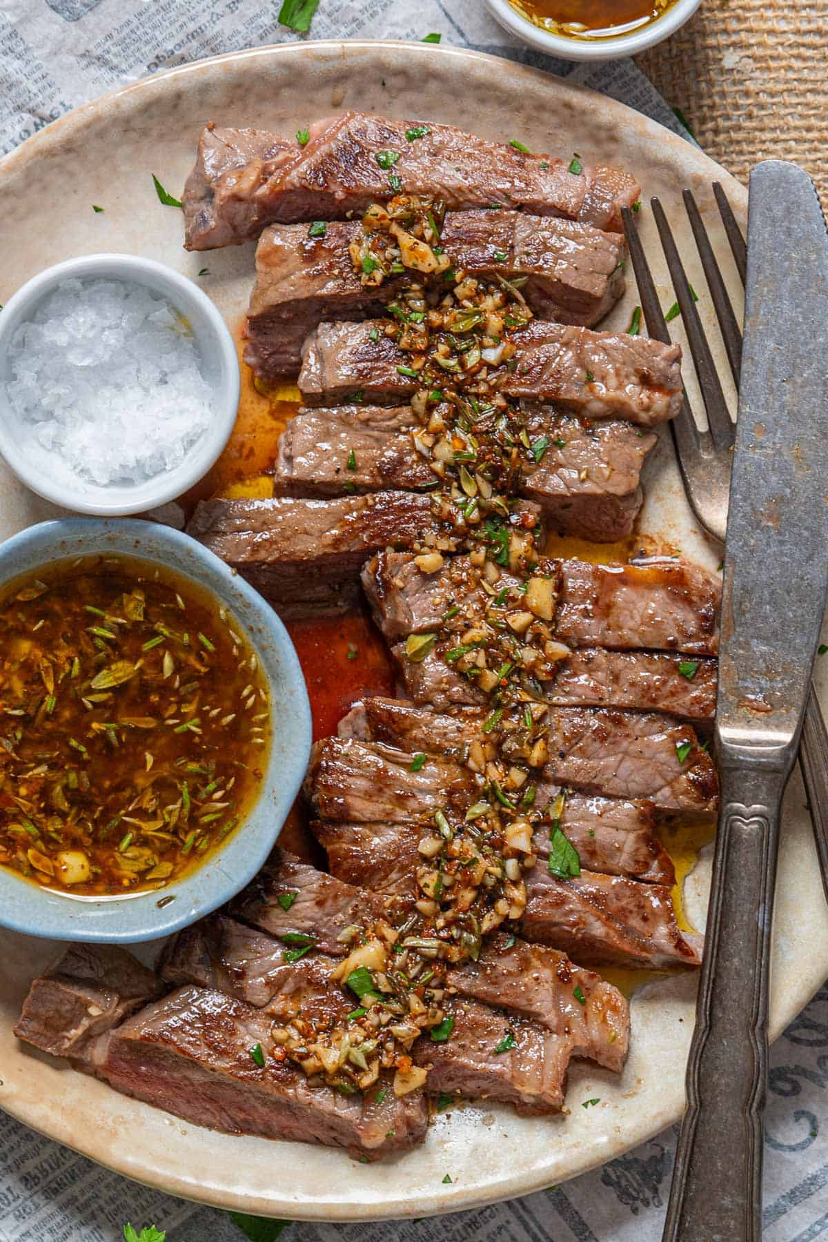 Grilled meat served on a plate with Argentine chimichurri.