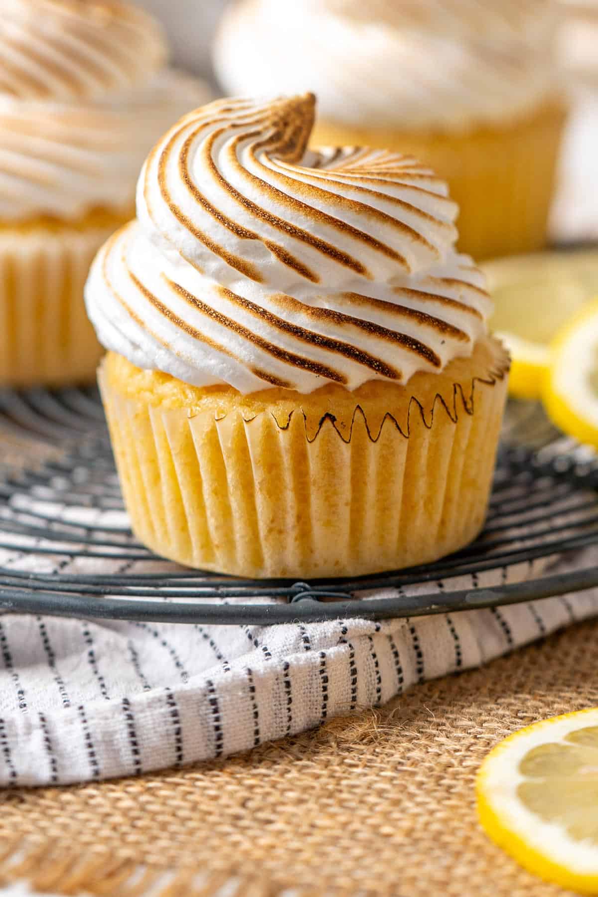 Lemon meringue cupcakes on a rack.