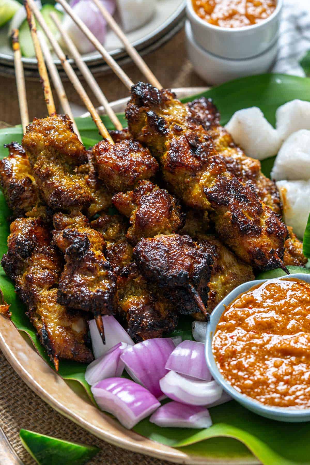 Malaysian chicken satay served with its condiments and satay sauce.