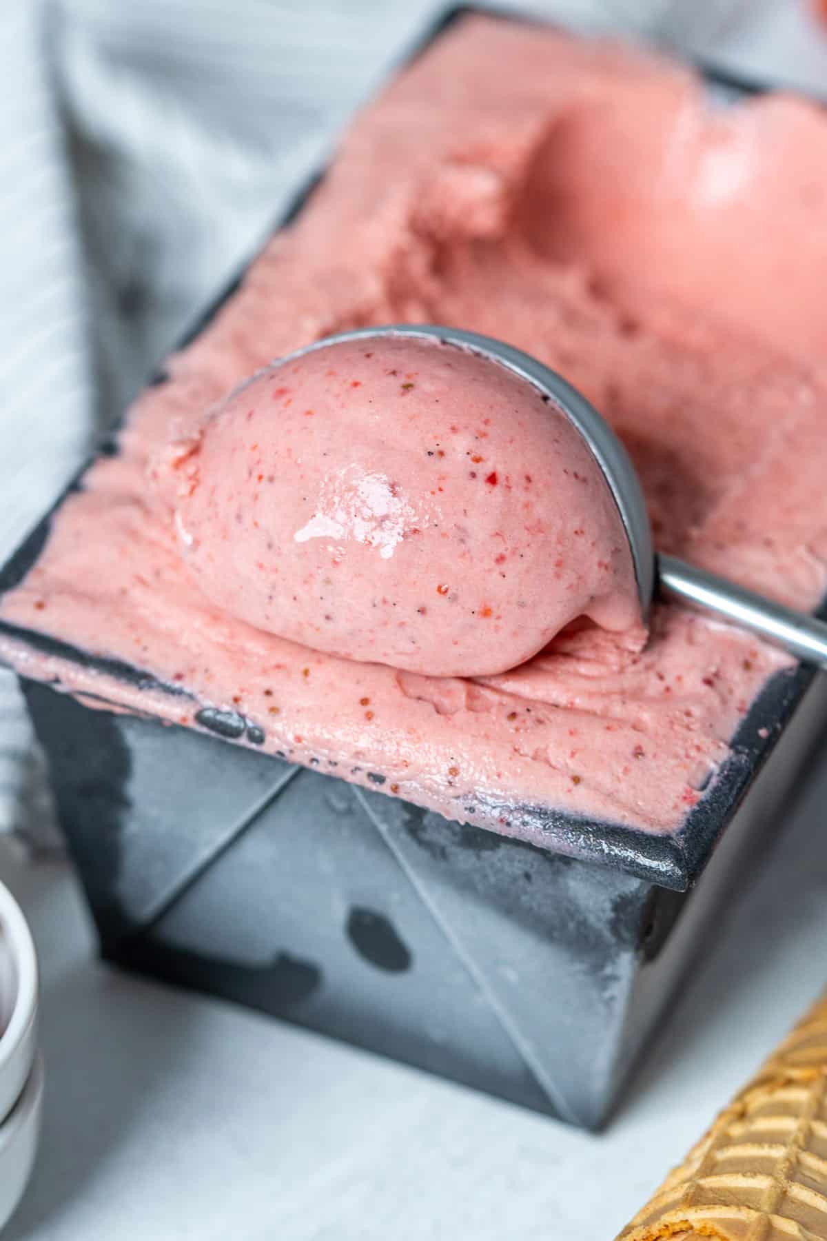 Scooping strawberry ice cream.