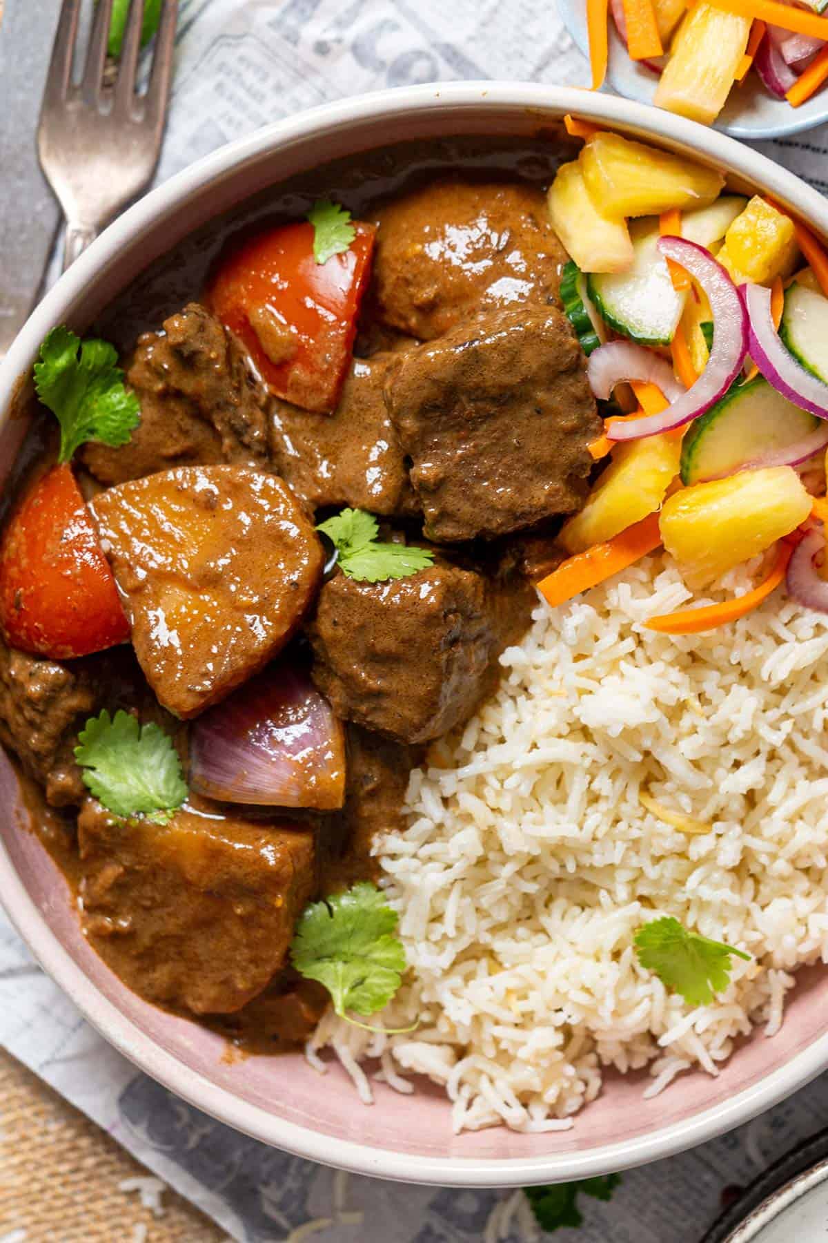 Beef korma curry with rice and salad.