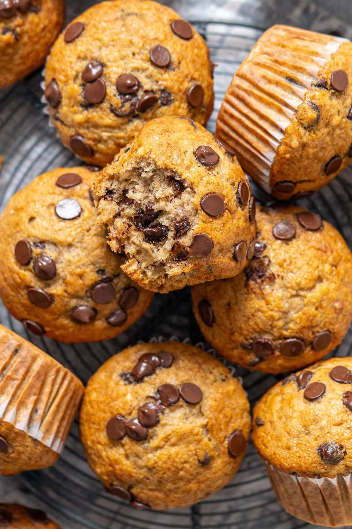 Half eaten muffin on top of other muffins.