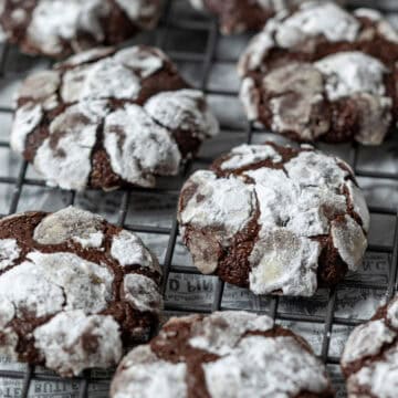 Chocolate crinkle cookies on a cooling rack.