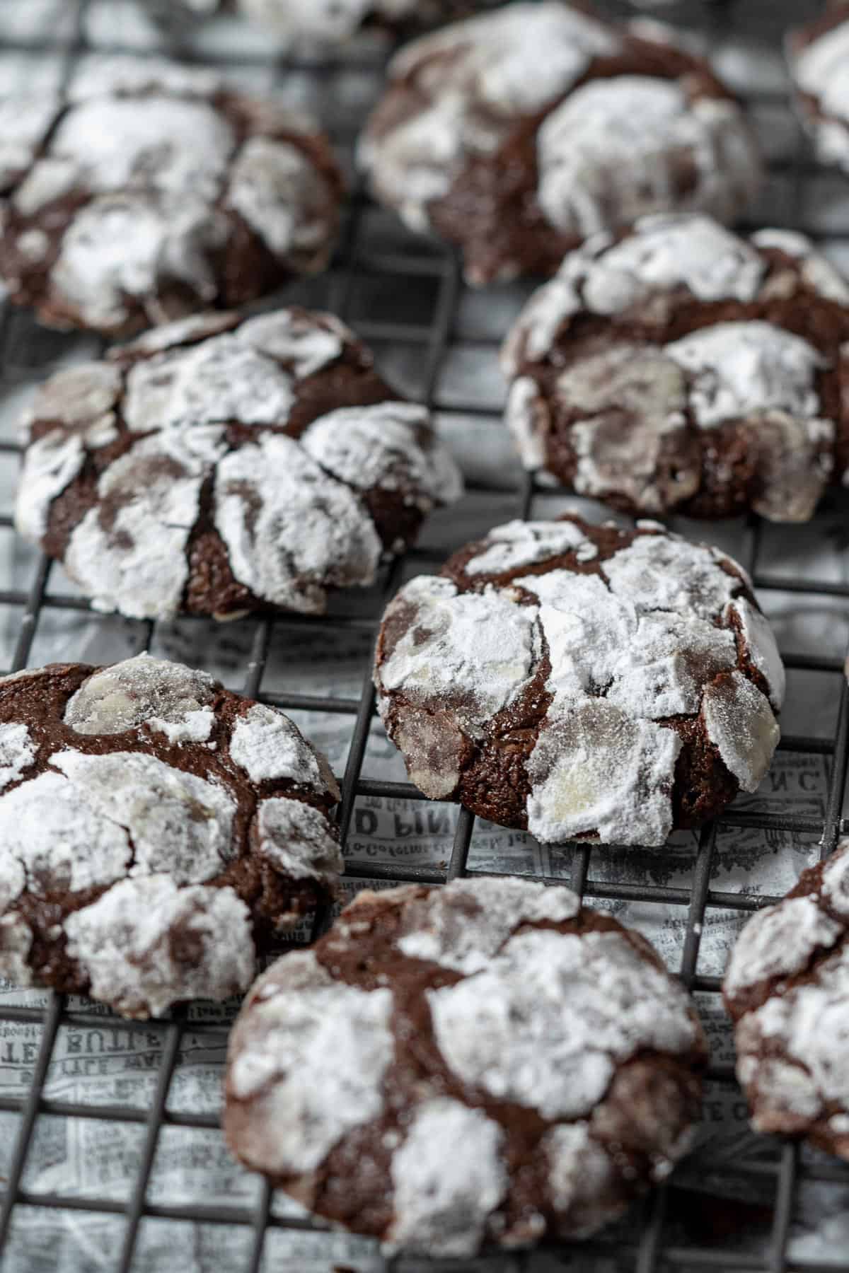 Chocolate crinkle cookies on a cooling rack.